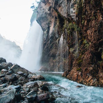 Stunning waterfall in Kayseri, Türkiye, cascading down a rocky cliff surrounded by mist and nature.