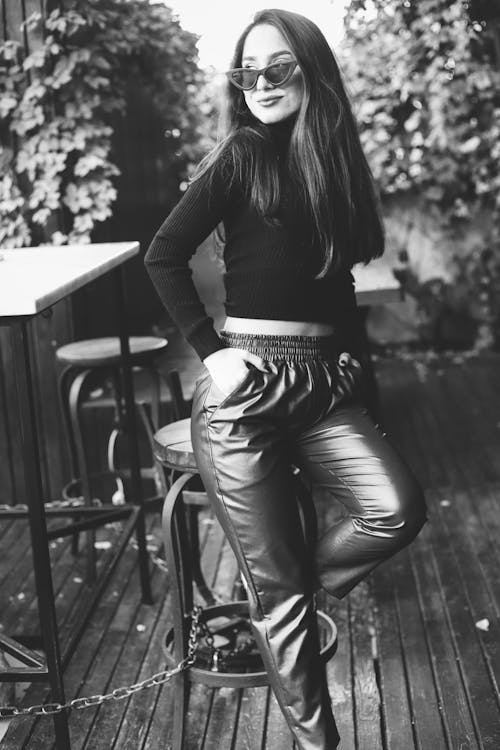 Woman Wearing Leather Pants Leaning on a Table · Free Stock Photo