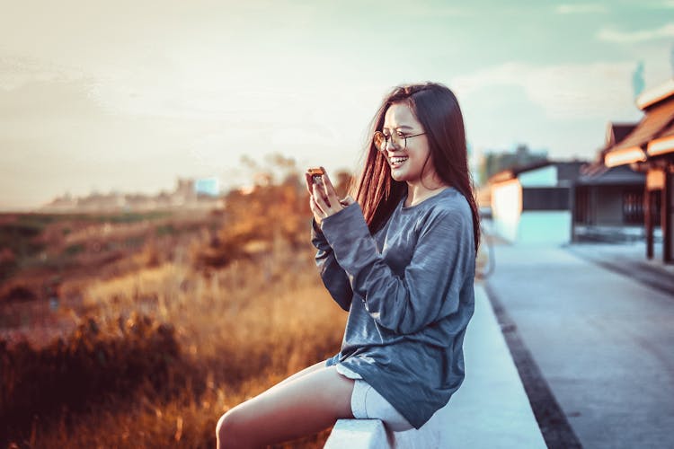 Woman Sitting Using Phone 