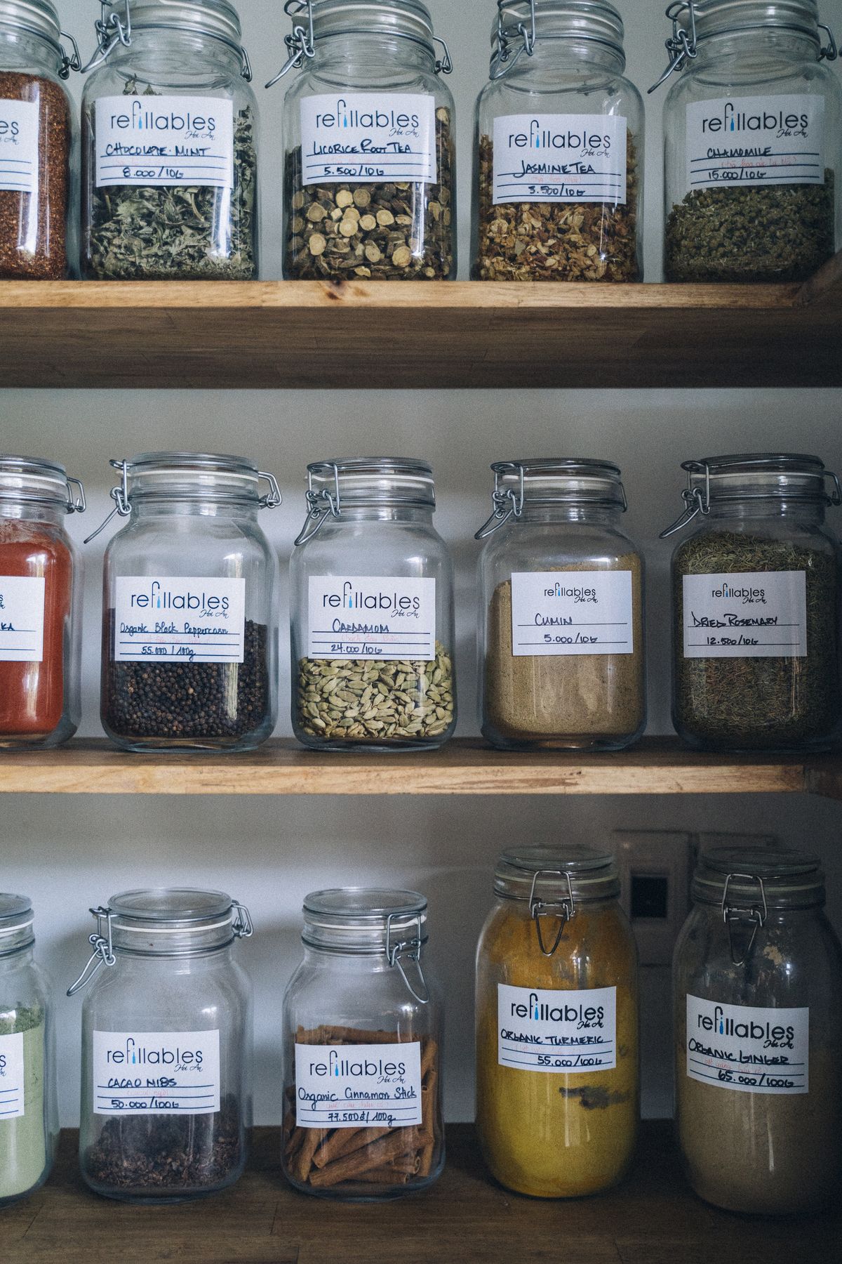 Glass food storage jars arranged on wooden pantry shelves
