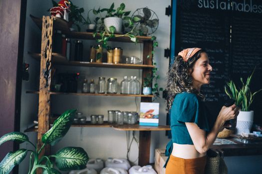 Woman in Blue T-shirt Standing Near Brown Wooden Shelf