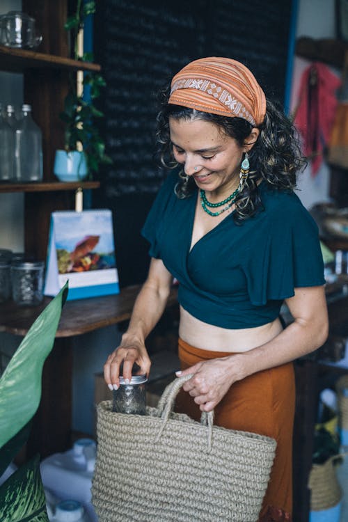 Woman in Blue Shirt and Brown Skirt Holding Glass Jar