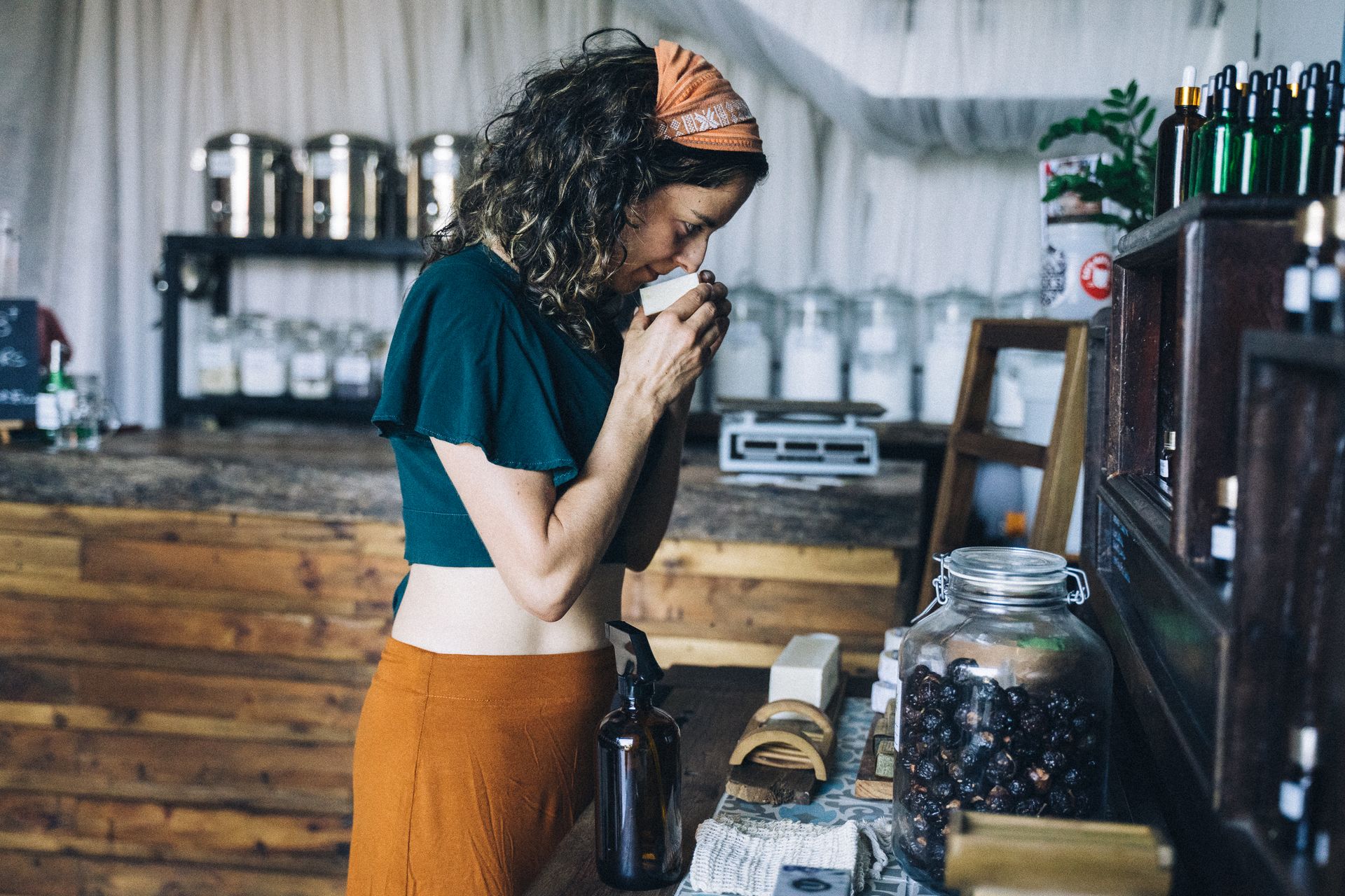 Woman in Blue Shirt and Brown Skirt Smelling a Soap