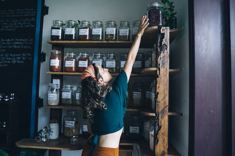 Woman Reaching At The Top Shelf