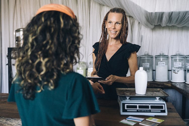 A Woman At The Counter Talking To A Customer