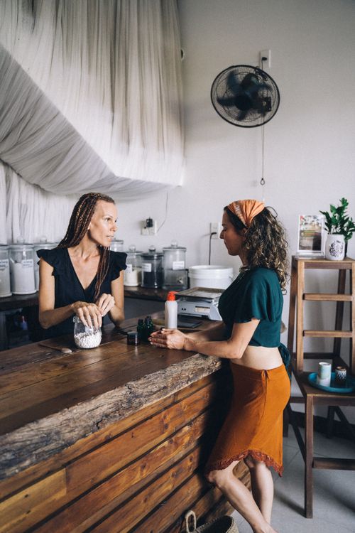 Free Two women engage in eco-friendly shopping with refillable containers in a store. Stock Photo