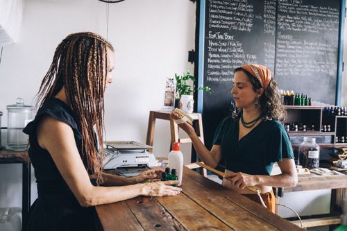 Free Two women interacting in an eco-friendly store, promoting organic products and sustainability. Stock Photo
