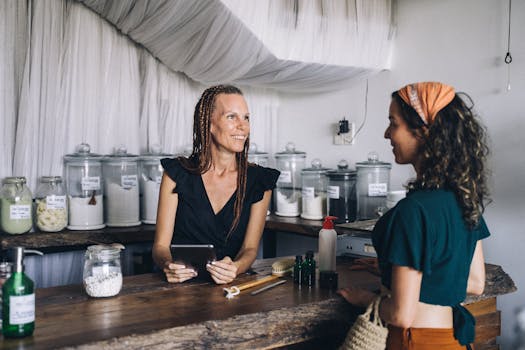 Woman using a tablet to assist customer in eco-friendly store with jars and eco products.