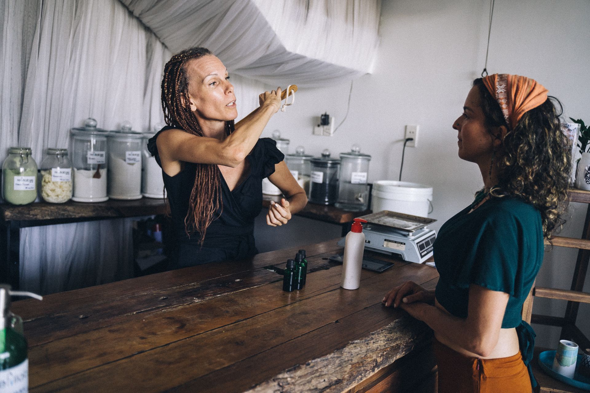 Two women engaging in eco-friendly shopping at a refill store with sustainable products.