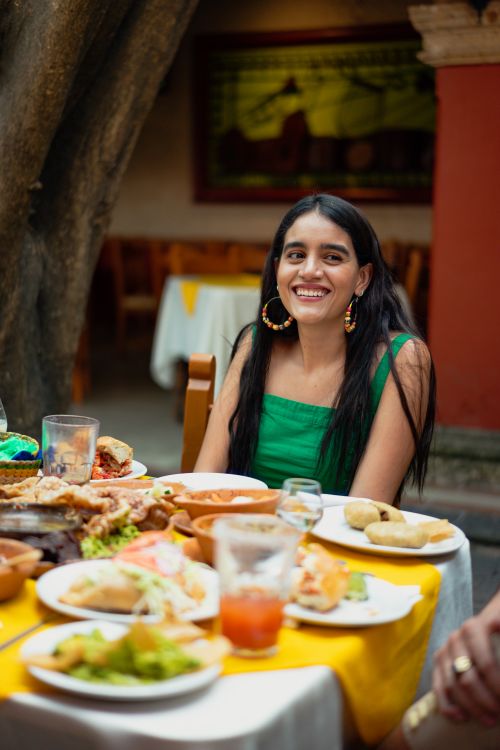 Free Woman enjoying traditional Mexican meal outdoors in festive setting. Stock Photo