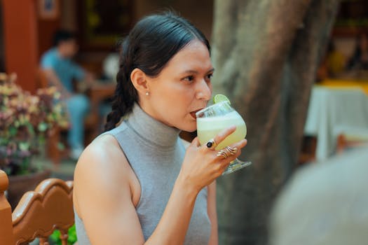 A woman drinks a margarita outdoors, capturing the essence of Mexican dining culture.