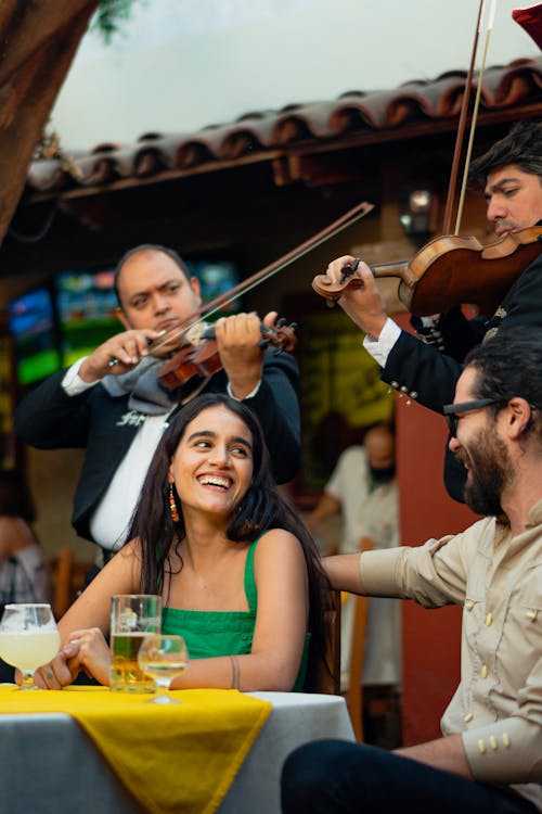 Free Group of Friends Eating while Listening to Mariachi Band Stock Photo