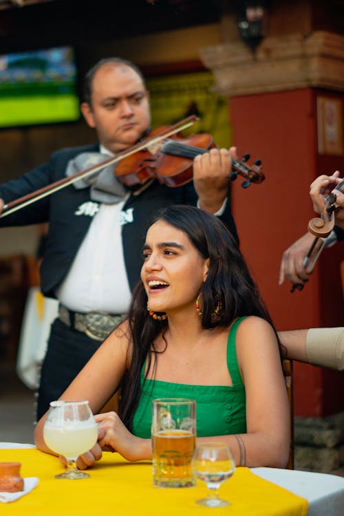 Free Woman in Green Tank Top while Listening to Mariachi Band Stock Photo