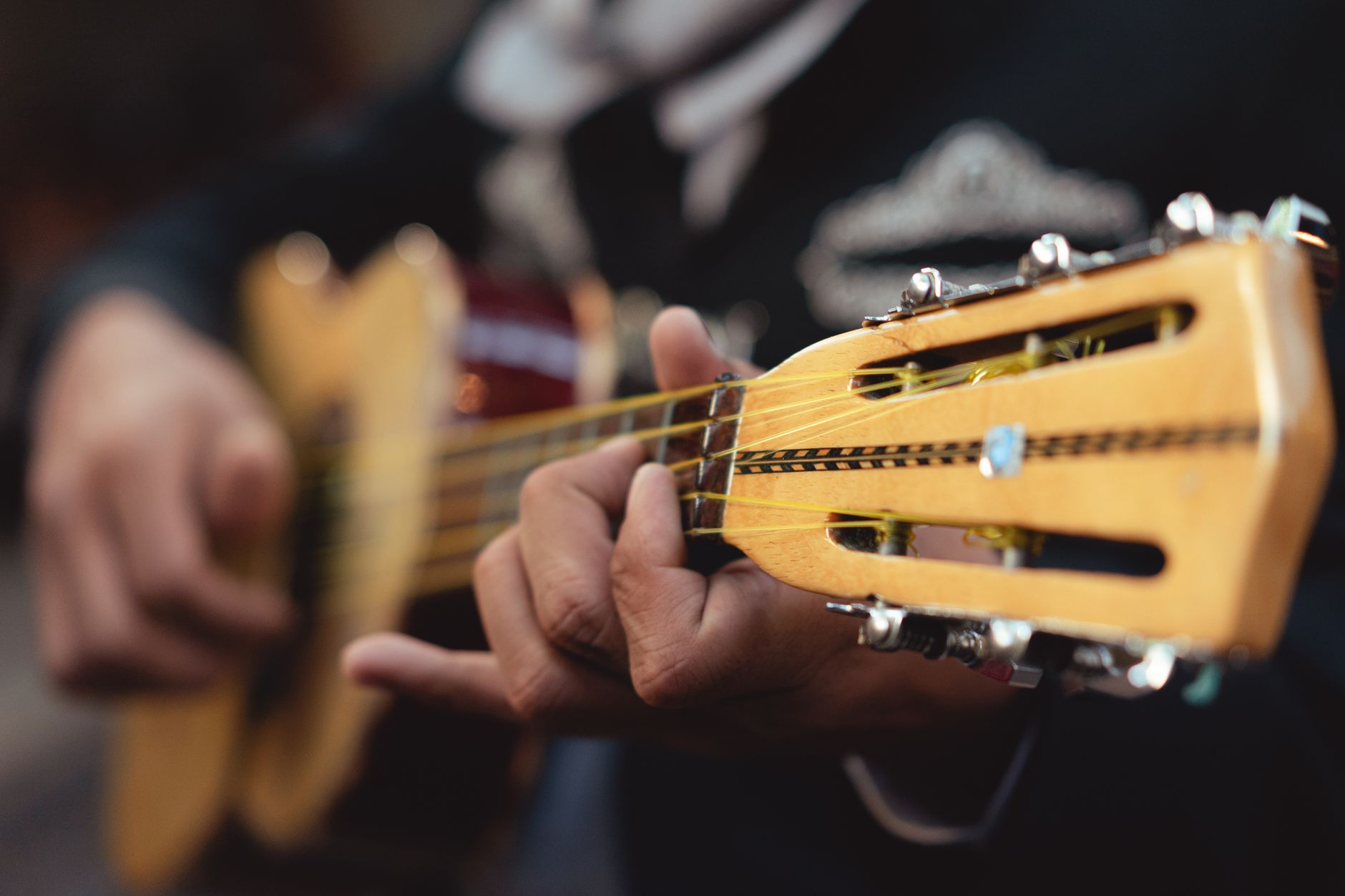 Detailed close-up of a mariachi musician playing a string guitar, showcasing skill and tradition.. pexels, detailed, close