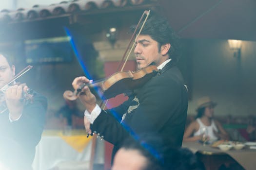 A mariachi violinist performing traditional Mexican music at an outdoor restaurant.