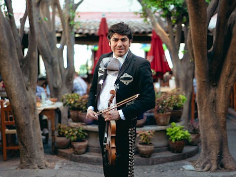 A mariachi violinist in traditional clothing captured outdoors amidst a vibrant Mexican setting.
