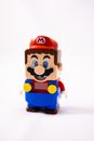 Isolated little multicolored toy figure of male metro worker placed against white backdrop