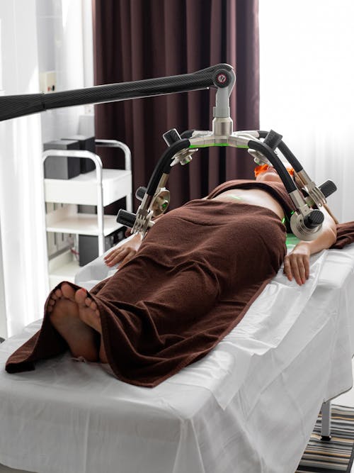 Free Faceless woman receiving weight loss procedure on table Stock Photo