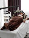 Faceless woman receiving weight loss procedure on table