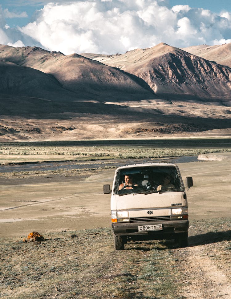 People Driving In Van In Mountainous Desert