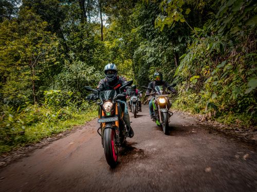 Free Group of motorcyclists riding through lush Indian forest trail, showcasing adventure and thrill. Stock Photo