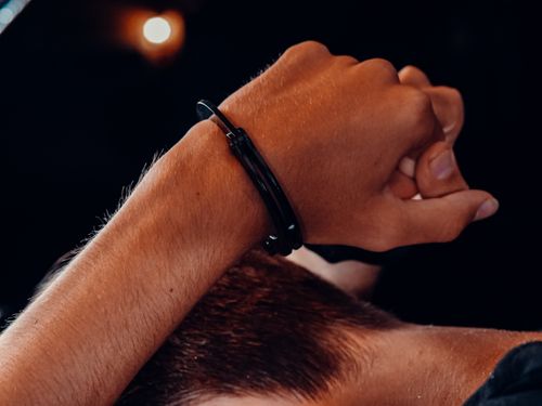 Free A close-up of a hand in handcuffs against a dark background, depicting a concept of security and restraint. Stock Photo