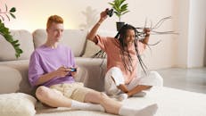 A Woman Sitting Beside a Man Playing Video Games