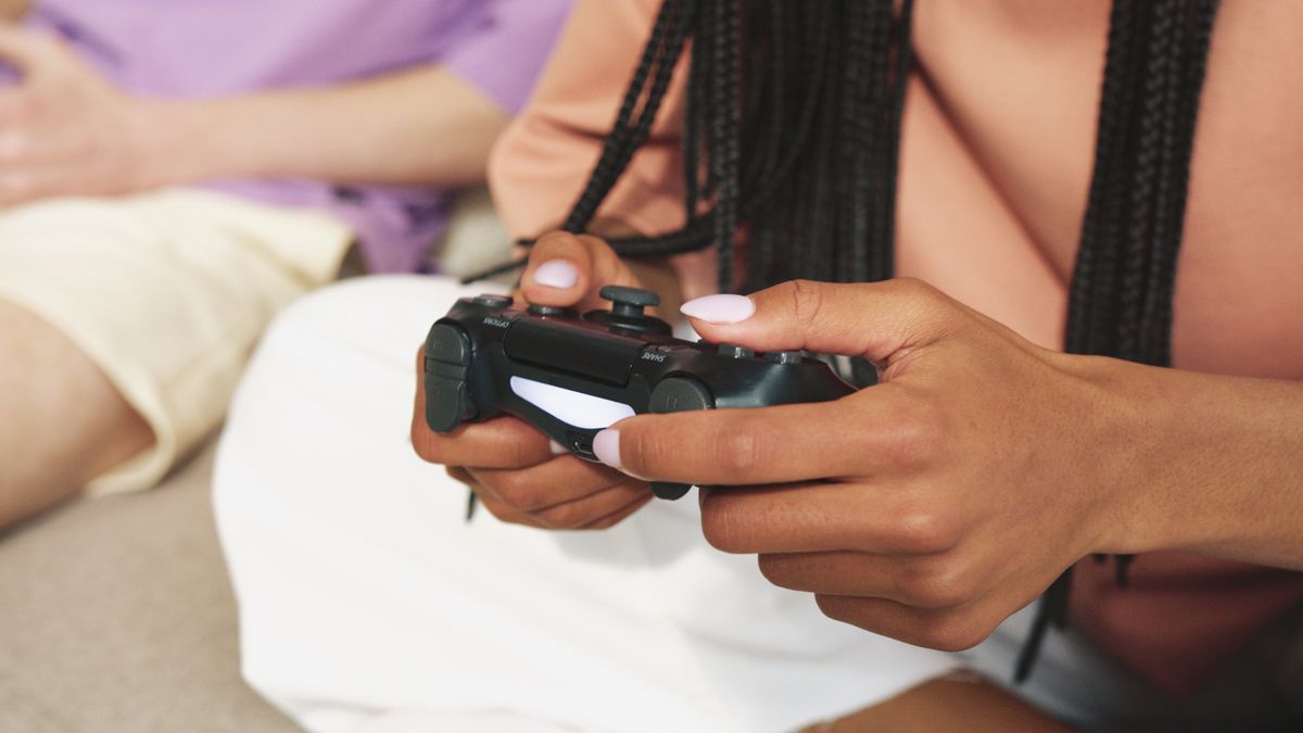 Person using a game controller in a dimly lit room