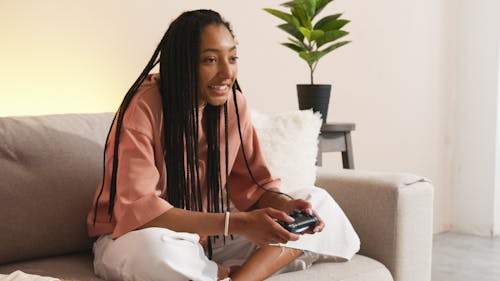 Woman in Pink Long Sleeve Shirt Holding Black Game Controller