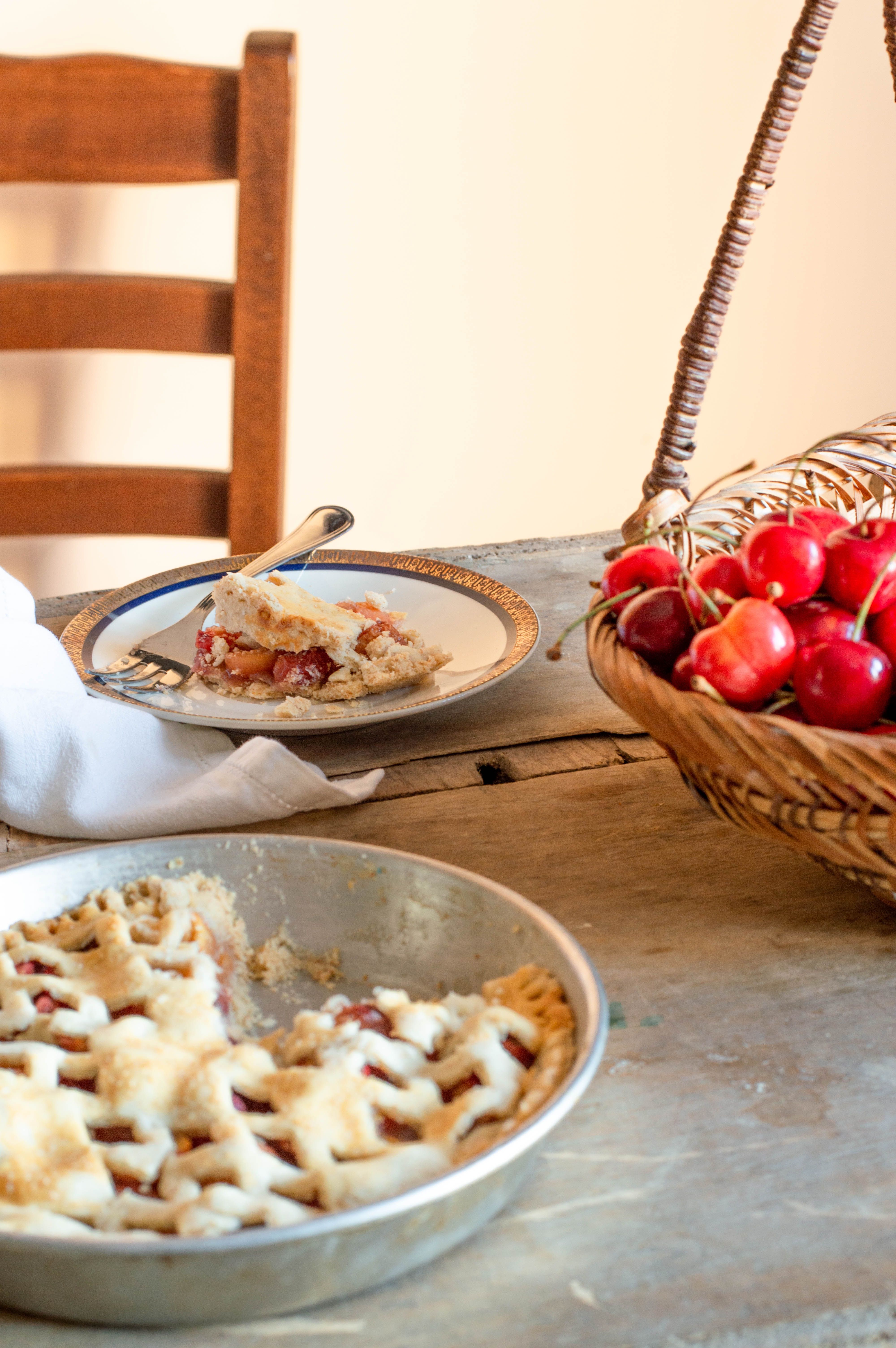 A homemade cherry pie with a lattice crust on a rustic wooden table, perfect for dessert lovers.