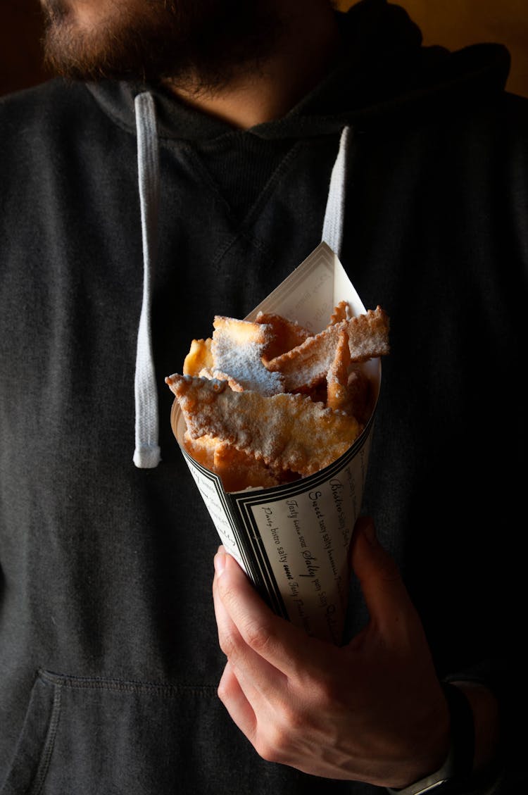 Man Holding Cone Of Sweet Powdered Fritters