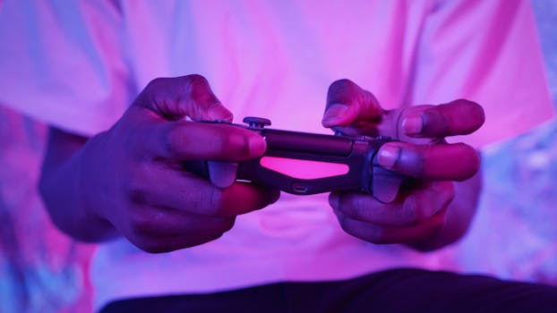Close-up of an adult holding a video game controller with pink lighting, highlighting gaming experience.