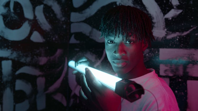 A Man Holding A Fluorescent Lamp Near Face