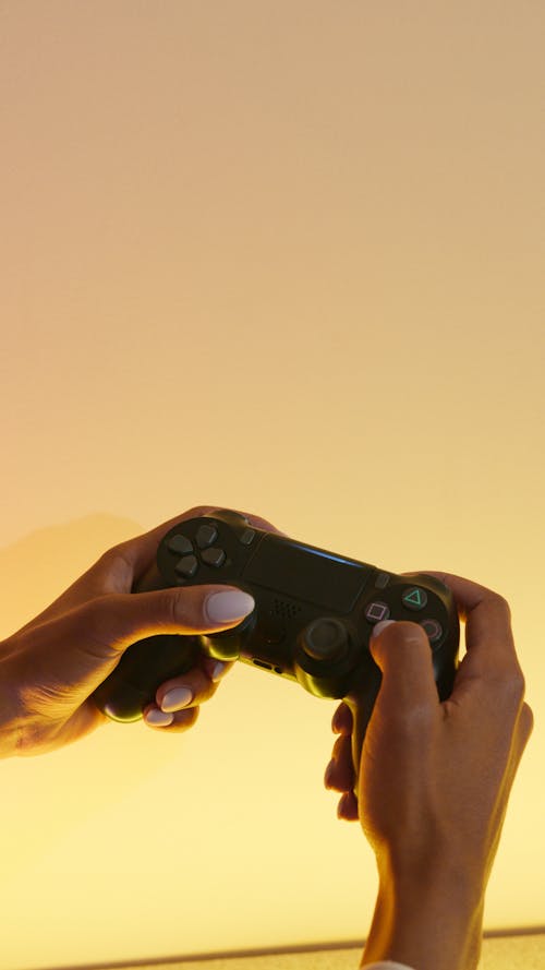 Free A Person Holding a Wireless Game Controller Stock Photo