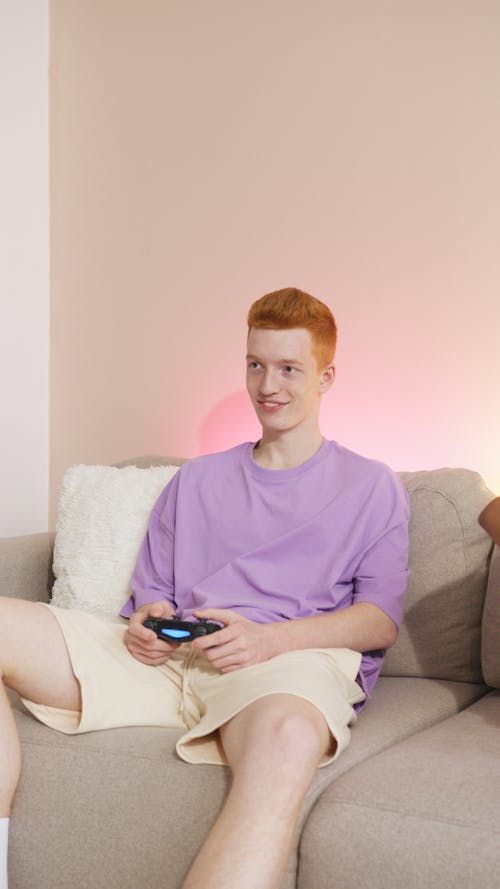 Free Person in Purple Shirt Holding Wireless Controller Stock Photo