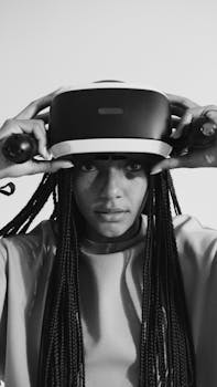 Black and white photo of a woman adjusting virtual reality headset, focusing on modern technology.