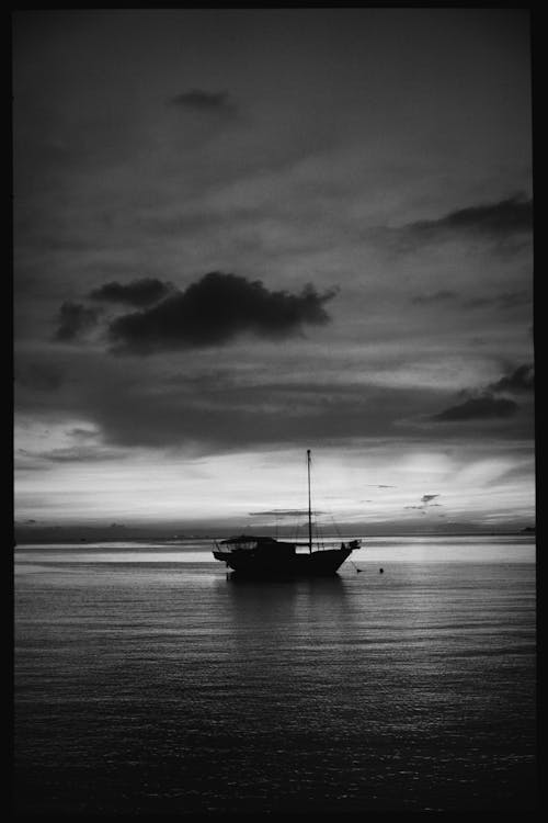 Free Black and white of ship floating on rippling sea water against cloudy sky Stock Photo
