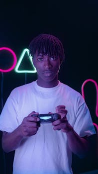 Portrait of an African American man with braided hair gaming in a neon-lit studio.