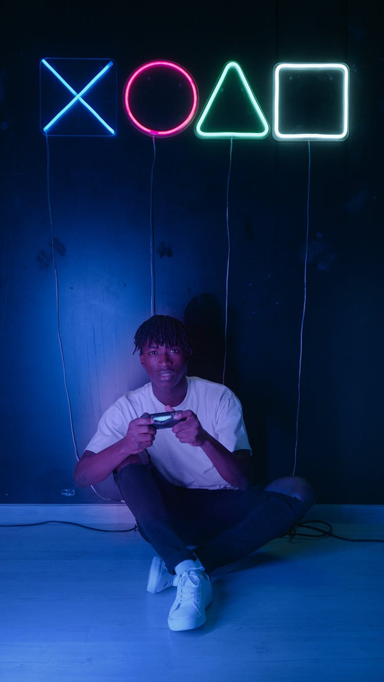 Man Sitting On Floor Holding A Game Controller