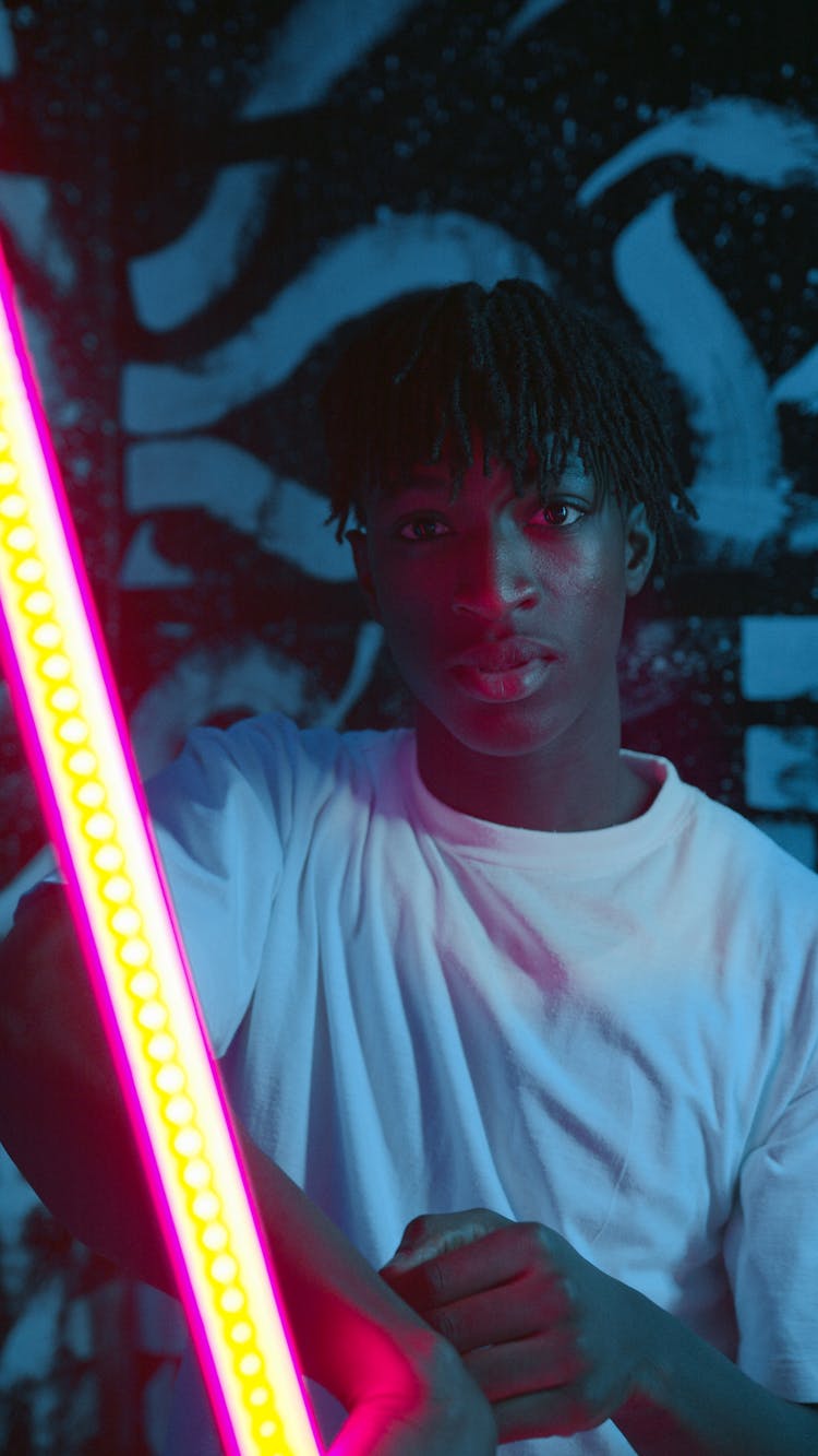 Man In White Crew Neck T-shirt Holding A Neon Glow Stick