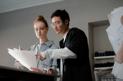 Free Two designers focused on creating fashion sketches together, highlighting teamwork and creativity. Stock Photo
