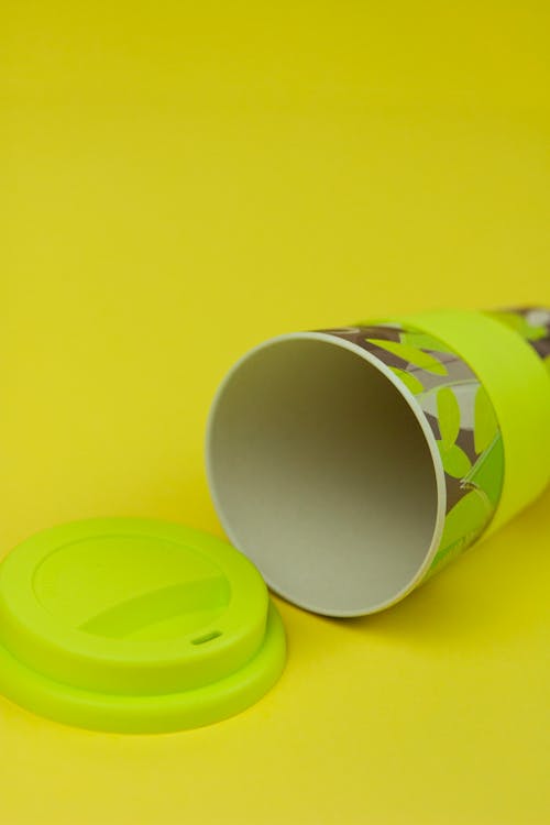 Studio Shot of a Paper Cup with Plastic Lid on Yellow Background