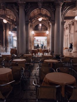 An elegant interior view of a historic café with arches, pillars, and ambient lighting.