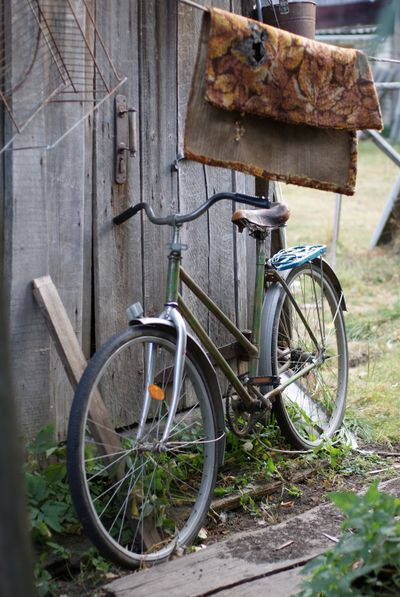 Weathered step-through bicycle leaning on a wooden shed — photo by Anna on Pexels