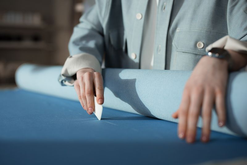 Tailor marking fabric with chalk before cutting