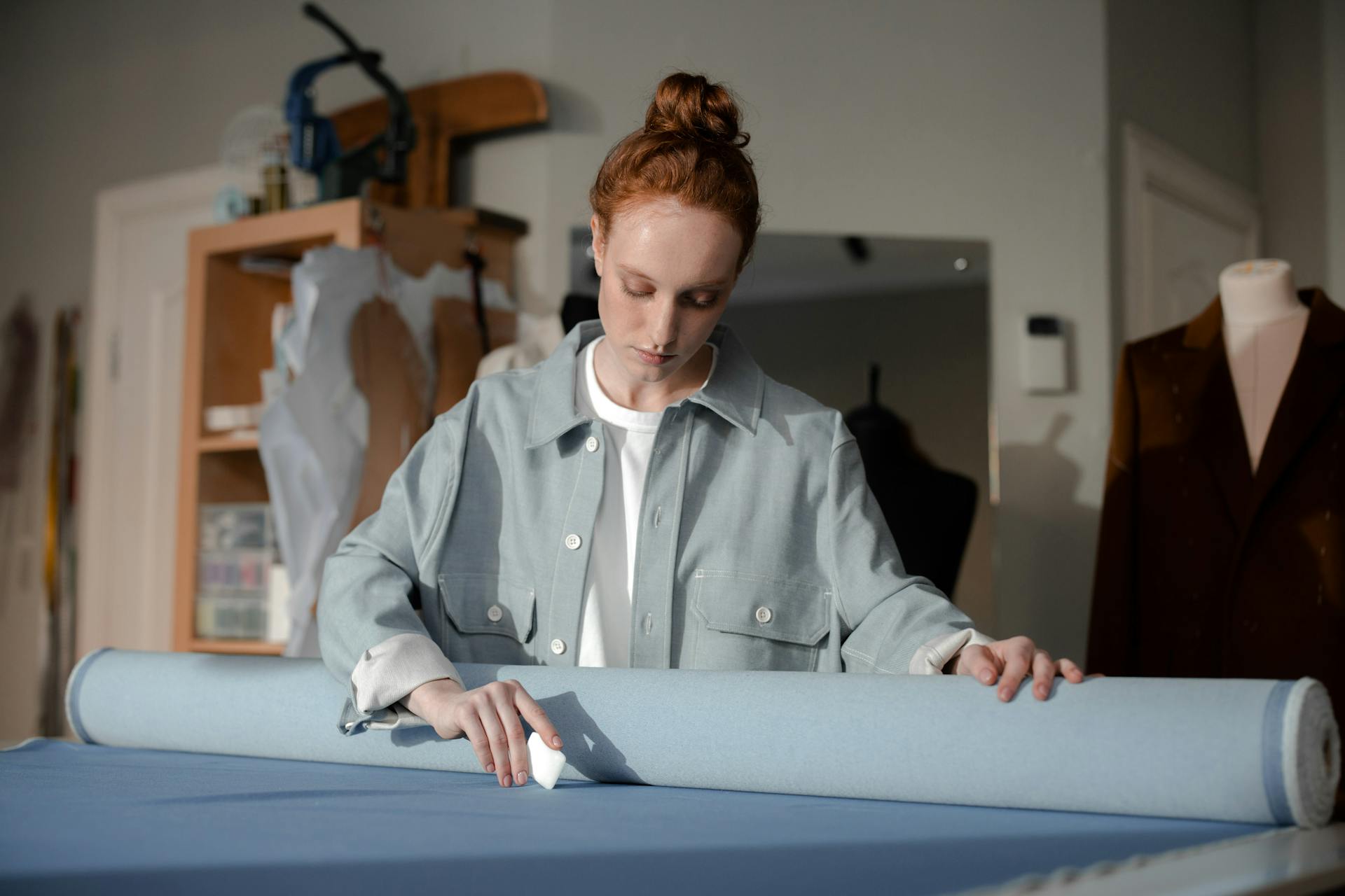 Woman in Gray Dress Shirt Marking A Fabric With Tailor's Chalk