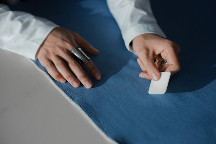 Person Marking A Blue Fabric With A Tailor's Chalk