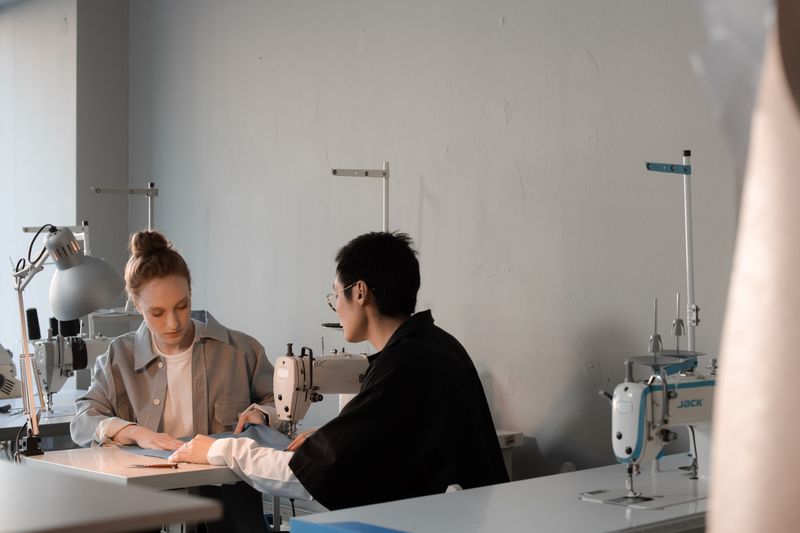 Two designers reviewing work at a studio bench — photo by Ron Lach on Pexels
