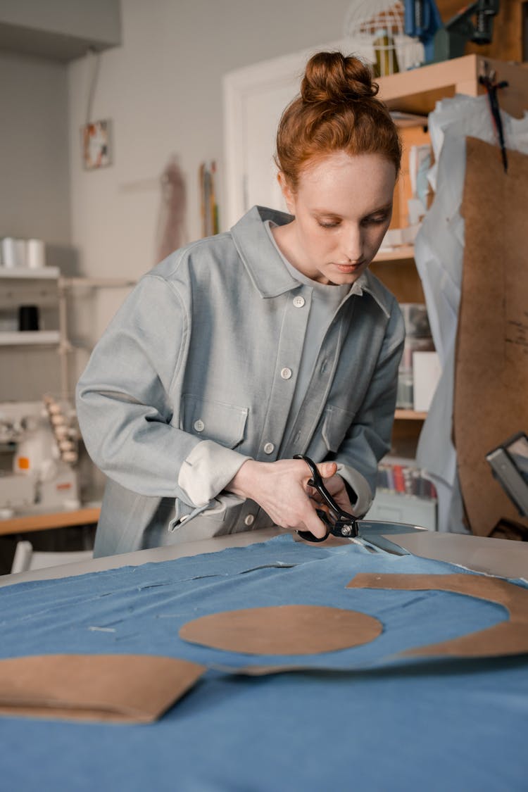 Woman Cutting A Fabric