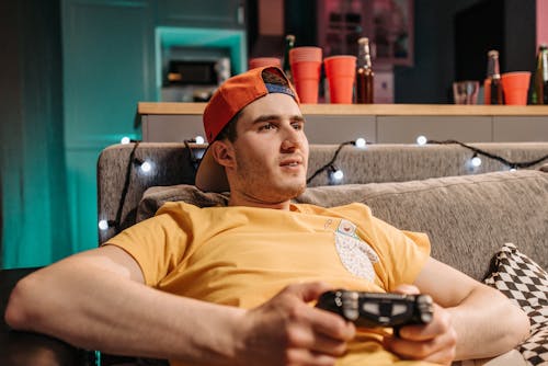 A Man Wearing a Yellow Shirt Playing a Video Game
